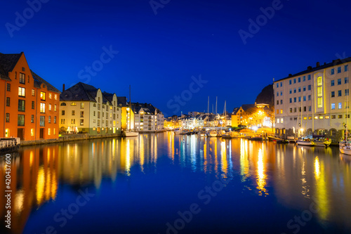 Architecture of Alesund city reflected in the water at night  Norway