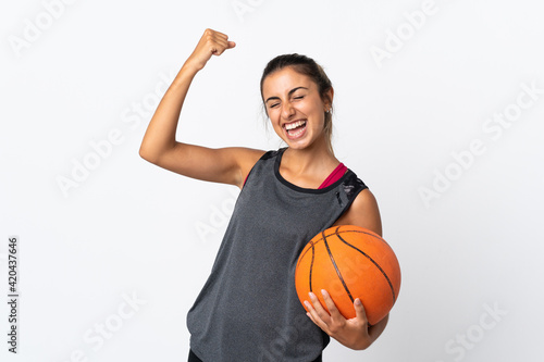Young hispanic woman playing basketball over isolated white background celebrating a victory © luismolinero