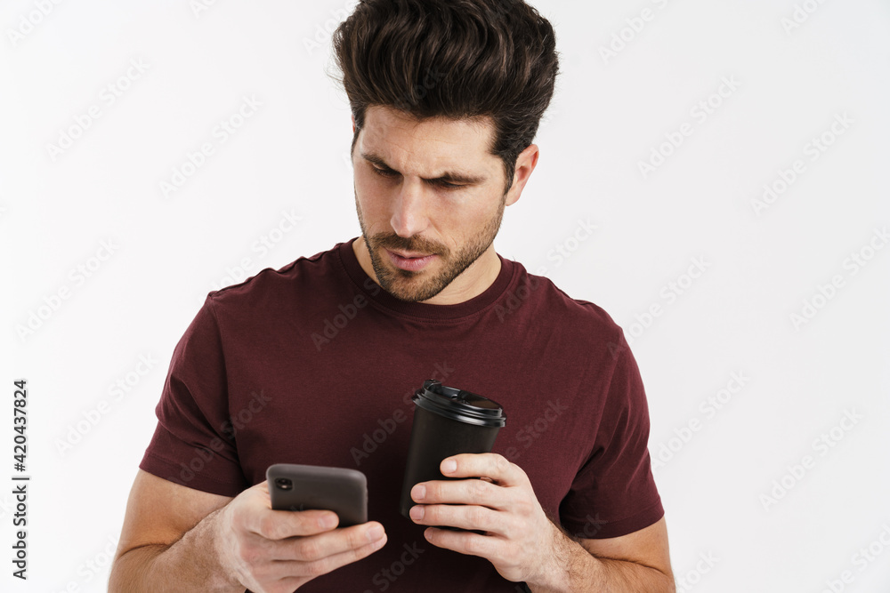 Focused handsome man drinking coffee and using mobile phone Focused handsome man drinking coffee and using mobile phone