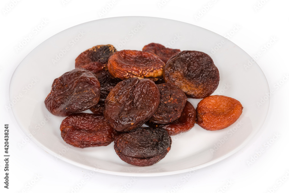 Dried smoked apricots on a white dish, selective focus Dried smoked apricots on a white dish, selective focus