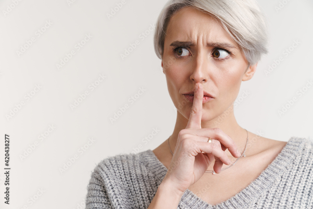 Displeased beautiful silver girl showing silence gesture Displeased beautiful silver girl showing silence gesture