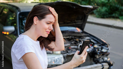 Tableau sur toile Scared woman in stress holding her head after auto crash calling to auto insurance for help