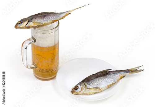 Salted dried roach fish on beer glass and on dish photo