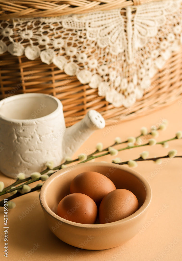 Fototapeta premium Easter eggs in natural color in a ceramic plate with pussy willow branches.