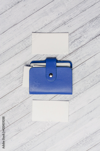 blue business card holder with letterheads on a wooden table top view