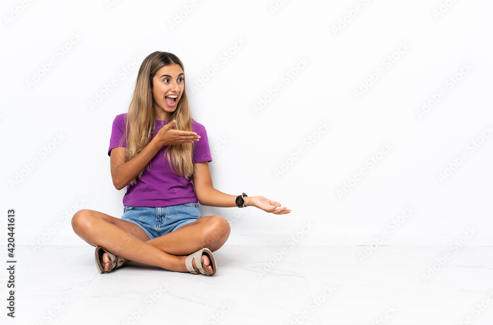 Young hispanic woman sitting on the floor with surprise expression while looking side Young hispanic woman sitting on the floor with surprise expression while looking side
