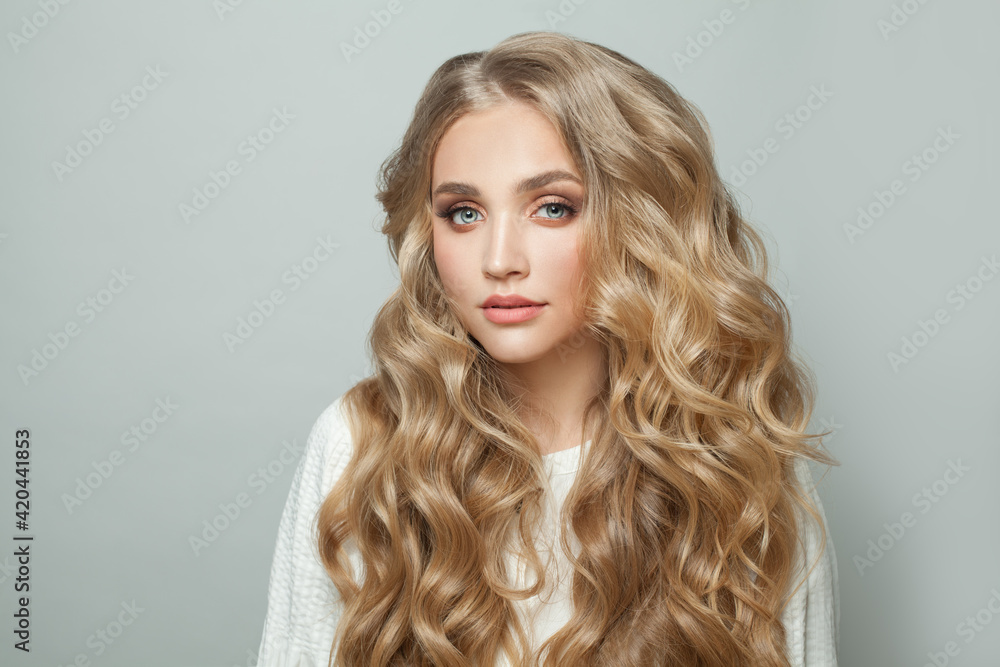Young perfect woman blonde model with with curly hairstyle on white background