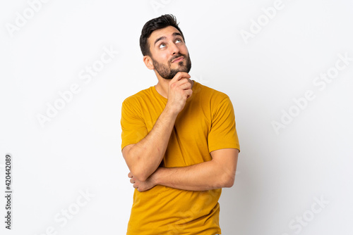 Young handsome man with beard isolated on white background and looking up