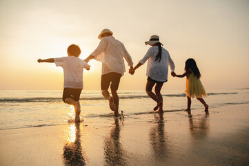 Happy asian family at consisting father, mother,son and daughter having fun playing beach in summer vacation on the beach.Happy family and vacations concept.