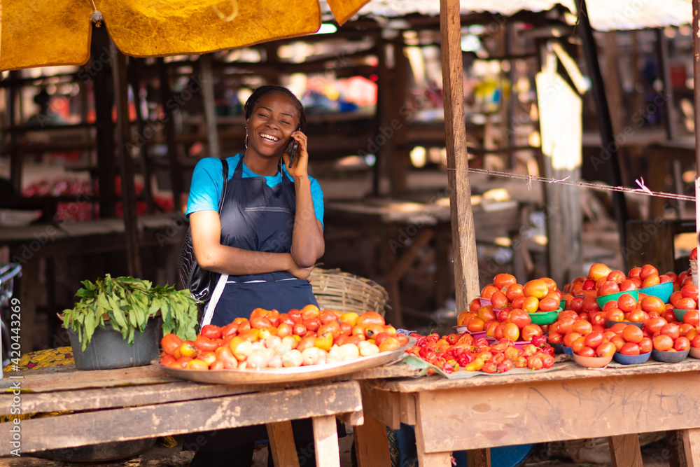african woman making a phone call in a market
