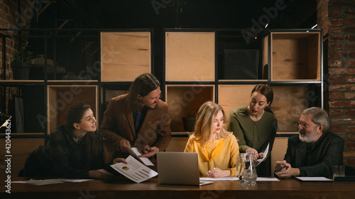 Paperwork. Young colleagues working together in a office styled like classical artworks. Look busy, attented, cheerful, successful. Medieval, renaissance mood. Concept of business, office, finance.