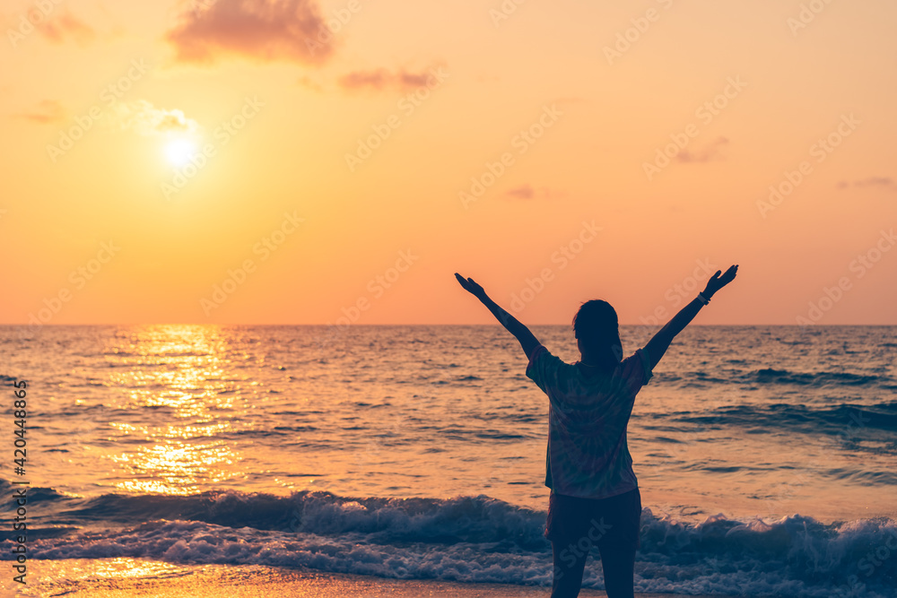 Copy space of woman rise hand up on sunset sky at beach and island background.