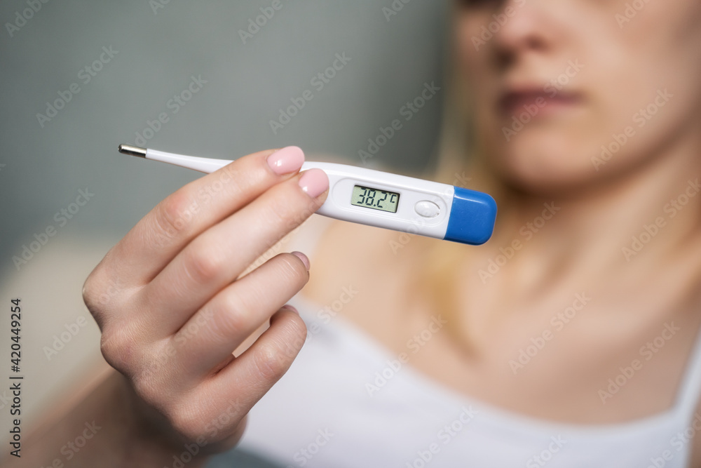 sick woman taking her temperature. sick woman taking her temperature.