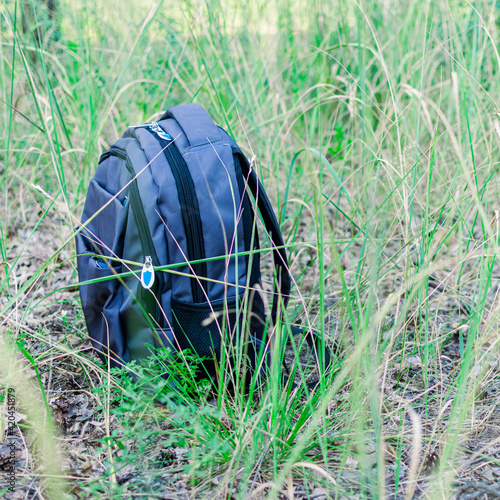 Urban backpack on the grass in summer. Hiking  outdoor activities concept.