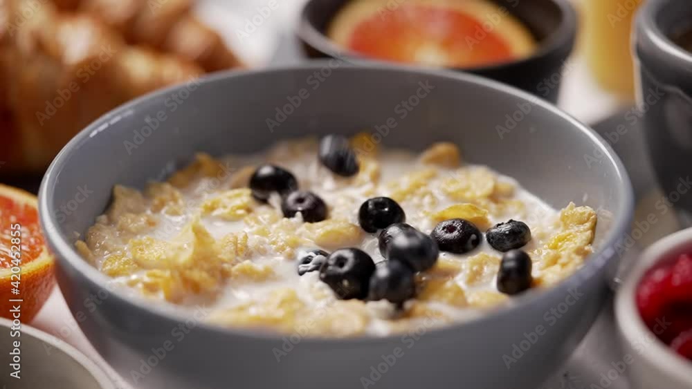 Falling berries into breakfast bowl filled with flakes and milk Falling berries into breakfast bowl filled with flakes and milk