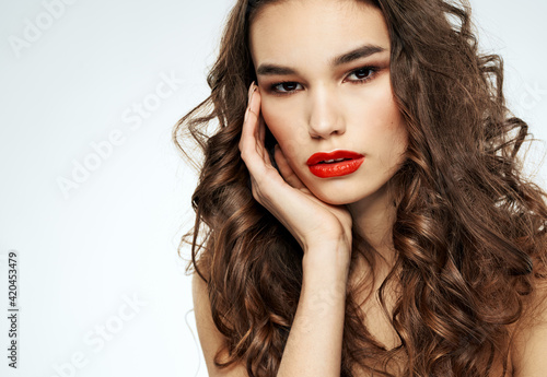 Portrait of a beautiful woman with red lips and curly hair at the barbershop