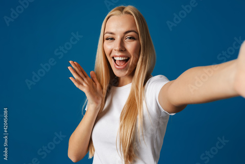 Blonde young happy woman smiling while taking selfie photo