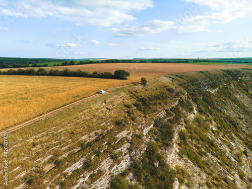 white car driving on top of hill