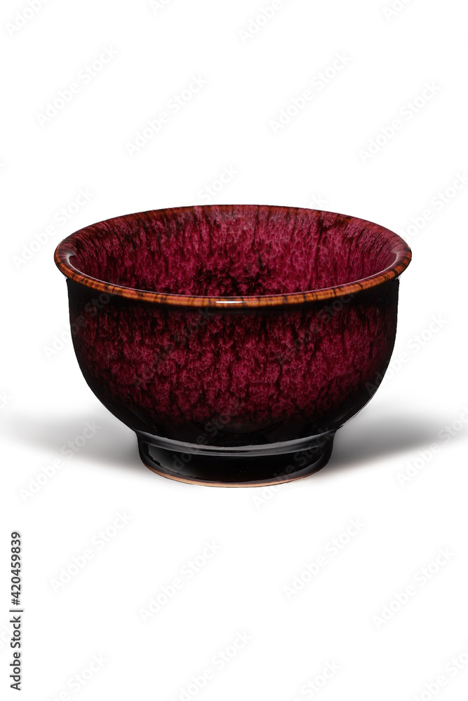 Subject shot of red ceramic bowl with glazed surface and traditional Chinese tianmu pattern. Simple tea bowl is isolated on the white background. Subject shot of red ceramic bowl with glazed surface and traditional Chinese tianmu pattern. Simple tea bowl is isolated on the white background.