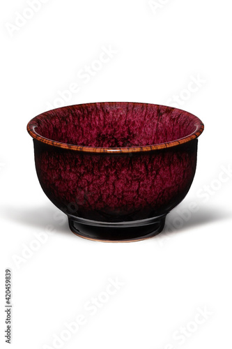 Subject shot of red ceramic bowl with glazed surface and traditional Chinese tianmu pattern. Simple tea bowl is isolated on the white background. photo