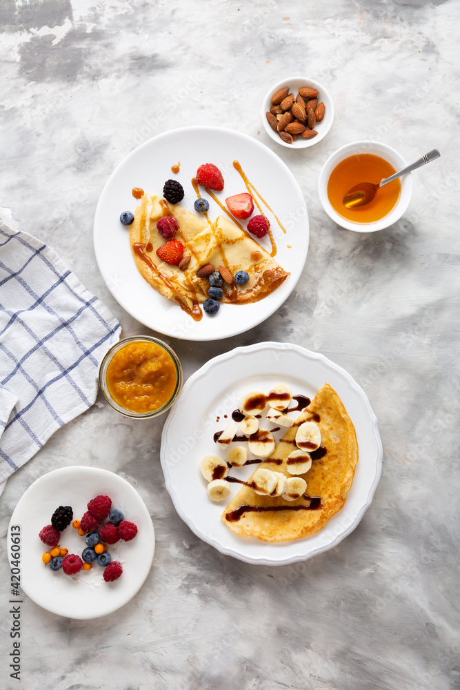 Overhead view of two plates with breakfast crepes, blini Overhead view of two plates with breakfast crepes, blini