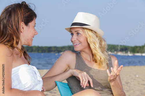 two beautiful female friends talking on beach
