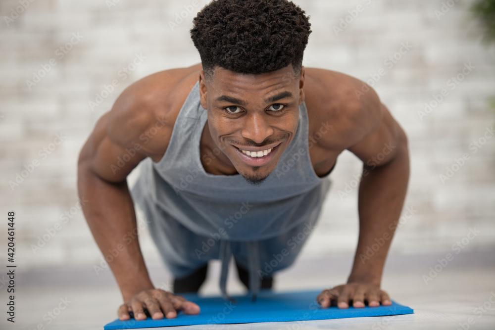Obraz premium muscular mixed race man in plank position