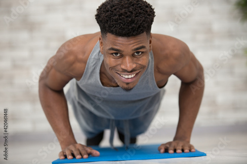 muscular mixed race man in plank position