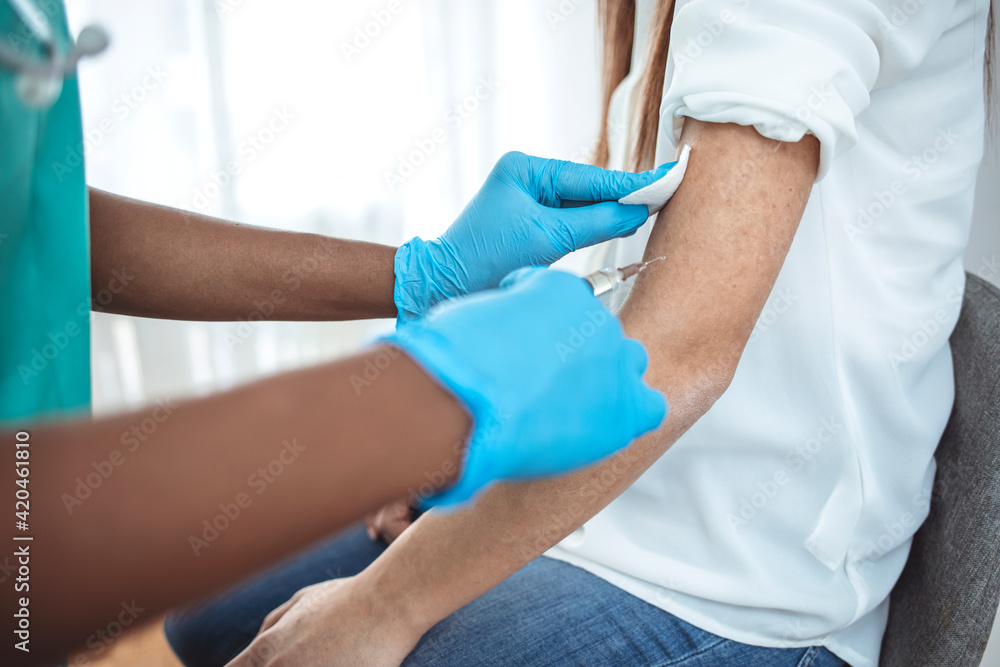 Hands with protective gloves fills syringe with vaccine. Hands of doctor in medical gloves injecting vaccine to a patient. Doctor giving muscular injection to woman. Vaccination healthcare concept. Hands with protective gloves fills syringe with vaccine. Hands of doctor in medical gloves injecting vaccine to a patient. Doctor giving muscular injection to woman. Vaccination healthcare concept.