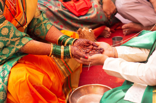 Bride and groom holding hand in Hindu religion wedding ritual photo