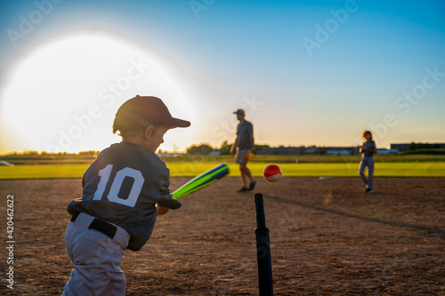 Canvas Print Youth batter hitting a tee ball into an open field at practice