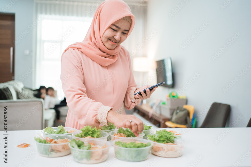muslim asian woman home catering service preparing lunch box for takeaway food online order