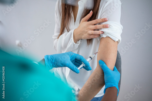 Vaccines. Professional Female Doctor in Blue Sterile Gloves Injecting Vaccine to Woman. Vaccination, Medicine and Healthcare. Covid, Coronavirus Vaccine. Young women receiving coronavirus vaccine
