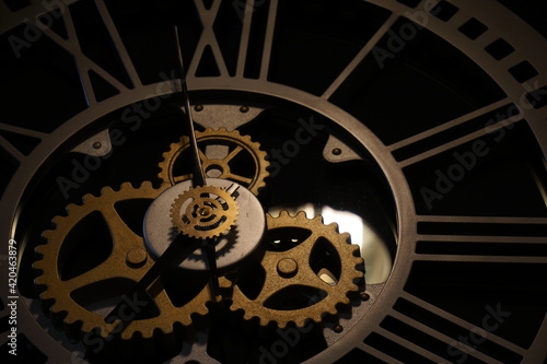 Old watch mechanism in the dark. Clock hands as symbol of time management.