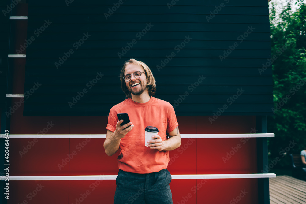 Laughing guy texting on smartphone