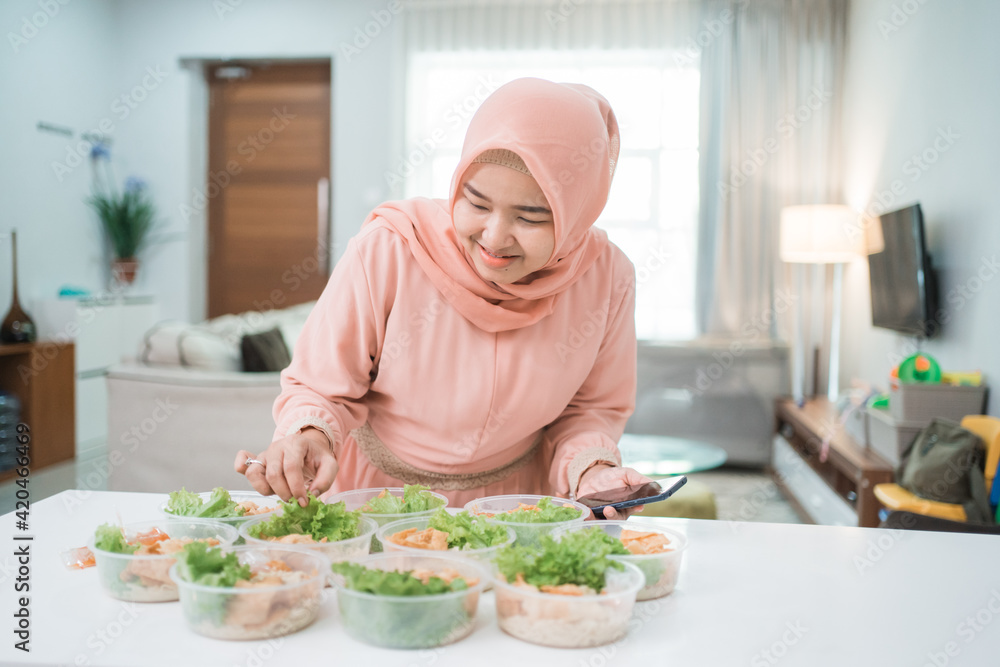 muslim asian woman home catering service preparing lunch box for takeaway food online order muslim asian woman home catering service preparing lunch box for takeaway food online order