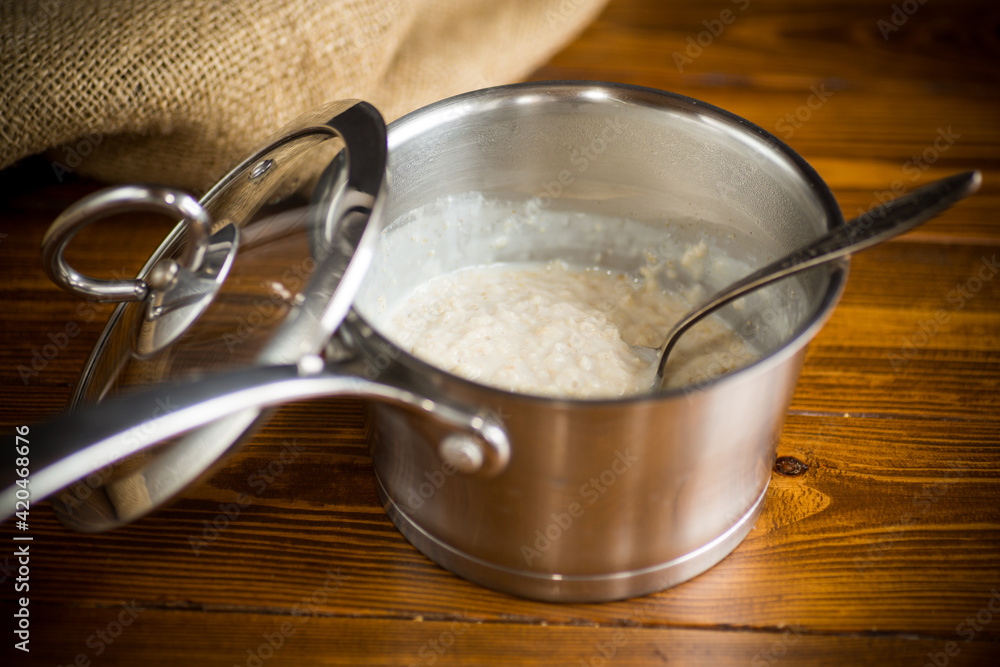 sweet boiled oatmeal in a saucepan with a spoon sweet boiled oatmeal in a saucepan with a spoon