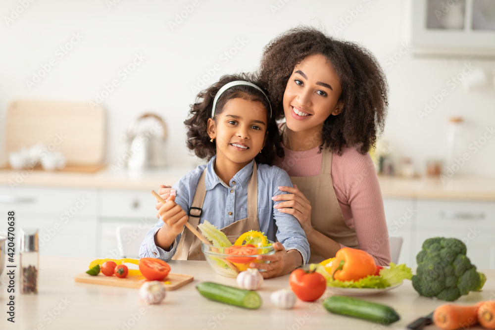 African american mother and daughter cooking tasty salad