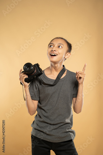 portrait of young photographer smiling holding his professional camera gear photo