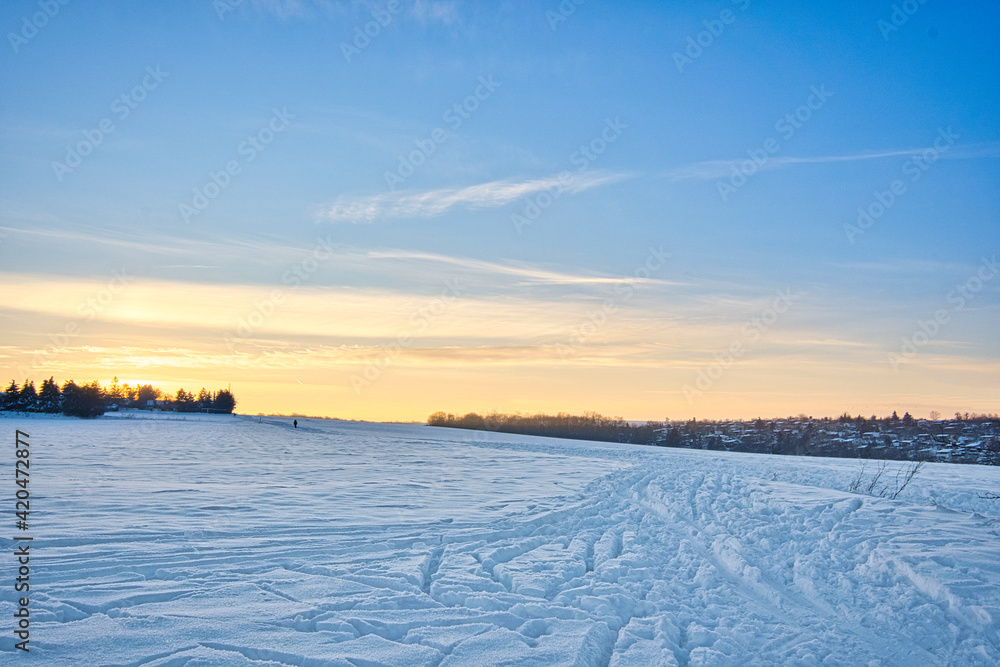 sunrise over the field in winter, blue sky with small clouds, space for text sunrise over the field in winter, blue sky with small clouds, space for text