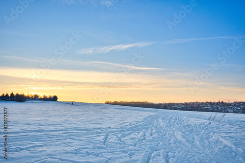 sunrise over the field in winter  blue sky with small clouds  space for text