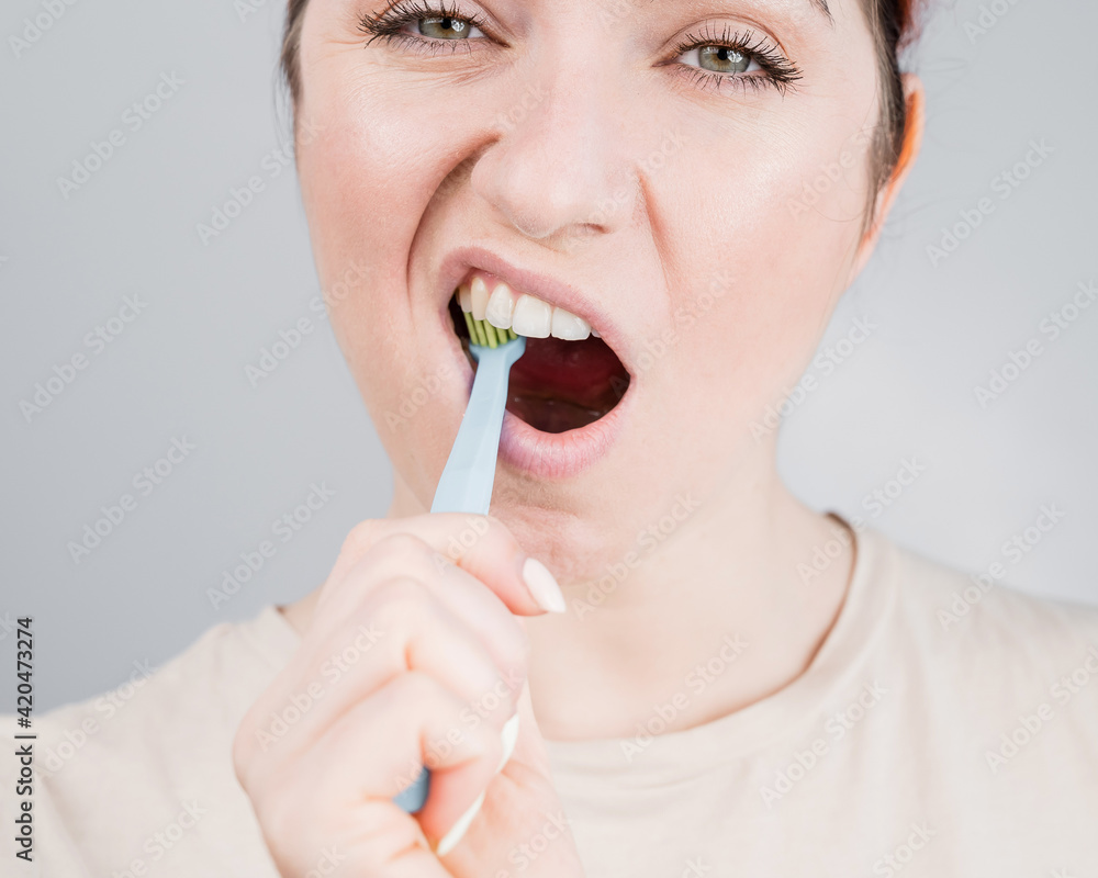 Close-up portrait of caucasian woman brushing her teeth. The girl performs the morning oral hygiene procedure Close-up portrait of caucasian woman brushing her teeth. The girl performs the morning oral hygiene procedure