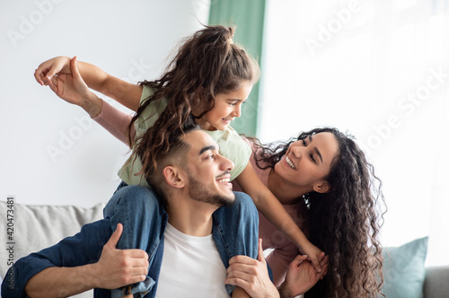 Cheerful Middle Eastern Family Of Three Having Fun Together At Home photo