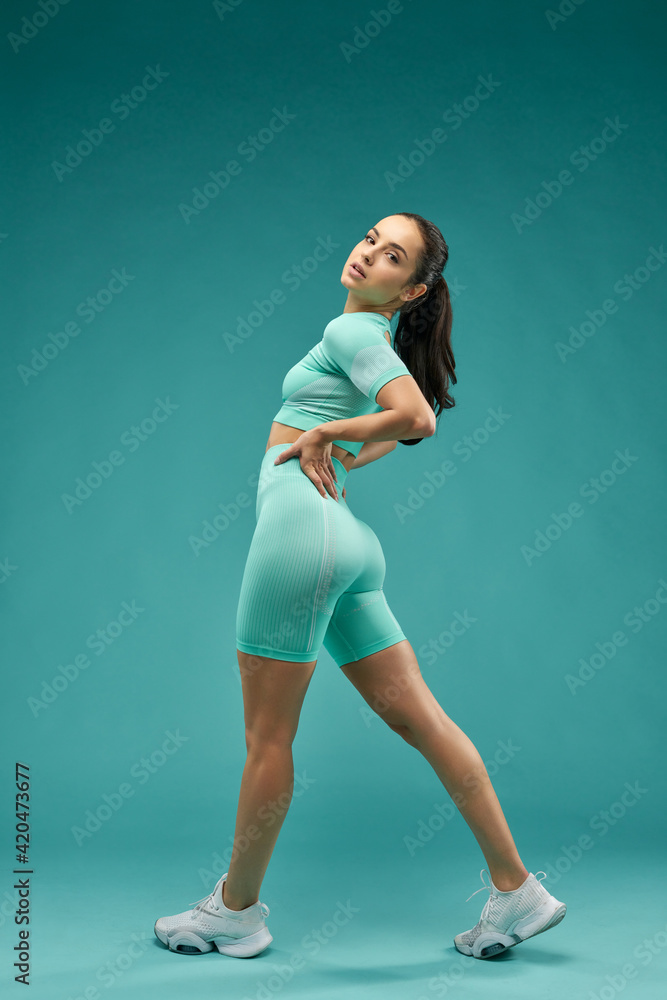 Fototapeta premium Fit young woman in sportswear looking over shoulder