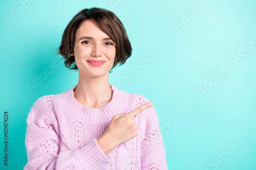 Photo of charming shiny young lady dressed purple pullover pointing finger empty space isolated teal color background