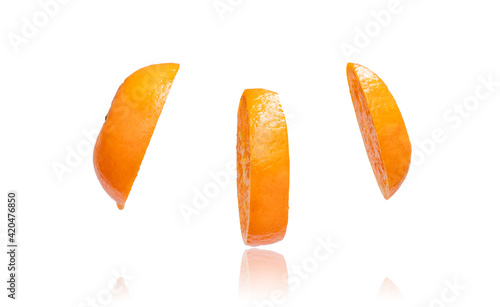 Flying orange. Sliced orange isolated on white background. Levity fruit floating in the air.