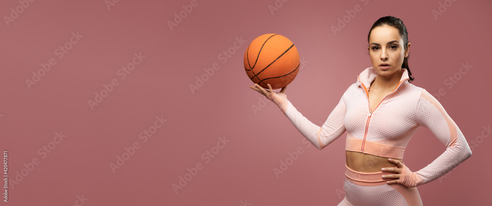 Website header of Sporty young woman with basketball ball posing in studio