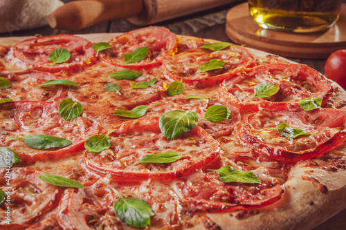 Brazilian pizza with tomato sauce, mozzarella, tomato, parmesan and basil (Pizza marguerita) - Closeup. photo