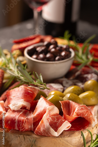 Charcuterie board with spanish jamon, pork sausage with pepper, fuet, cheese and berries. Traditional tapas