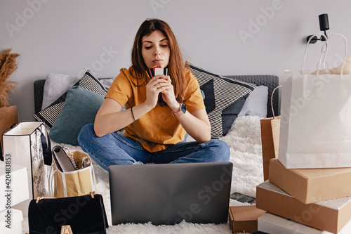 Woman shopping online using her laptop at home
